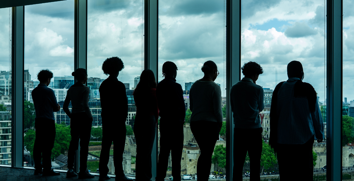 Image of young people standing and looking out a window.